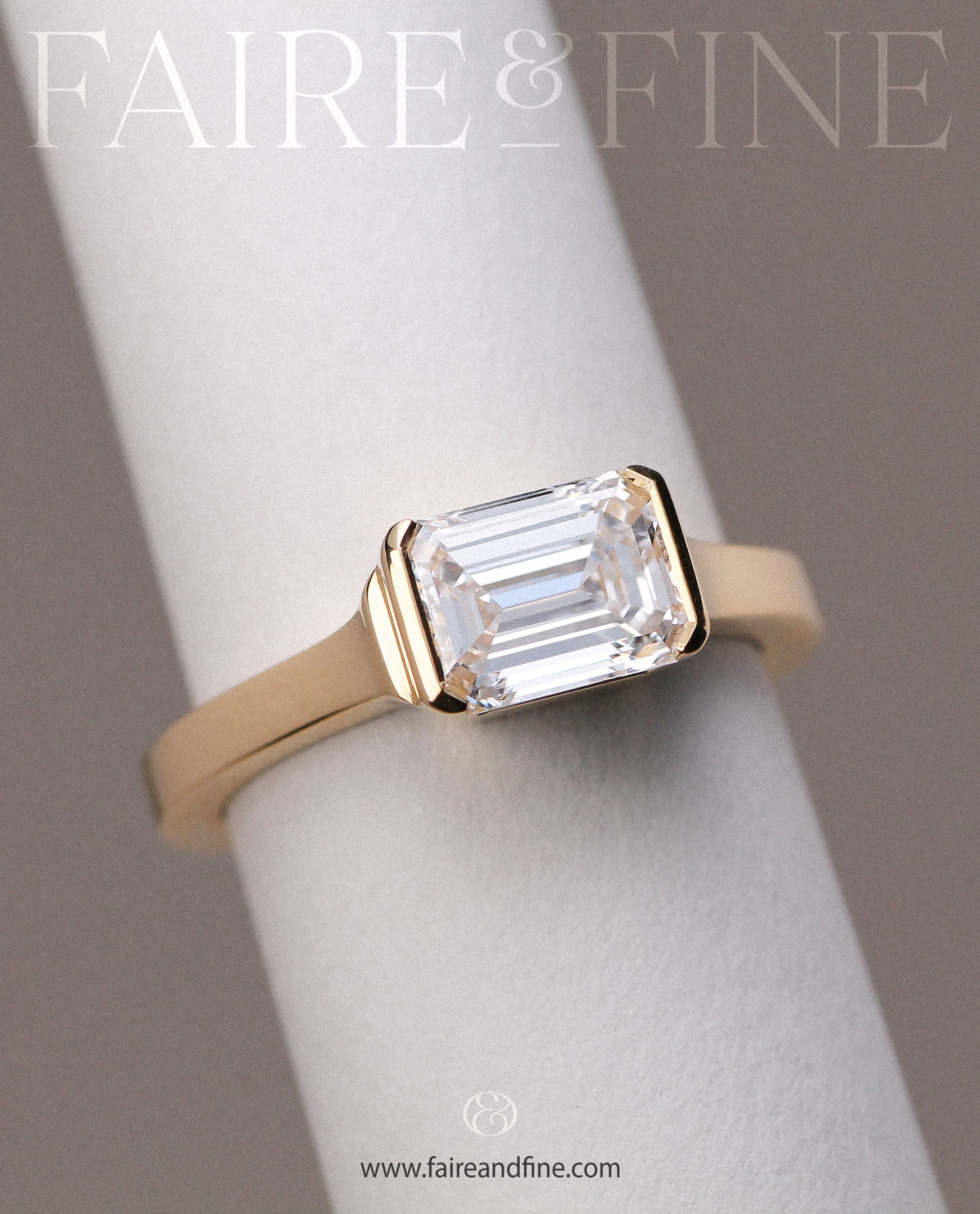 East-West emerald cut diamond engagement ring set in gold